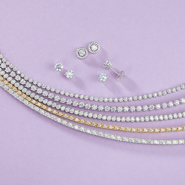 Diamond tennis bracelets and stud earrings on lavender background